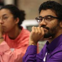 Two students listen intently during a presentation